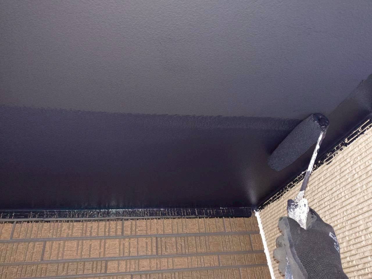 軒天を黒い塗料で塗装中